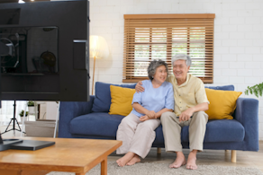 Life Assure Senior Couple Sitting On Couch Watching TV Blog